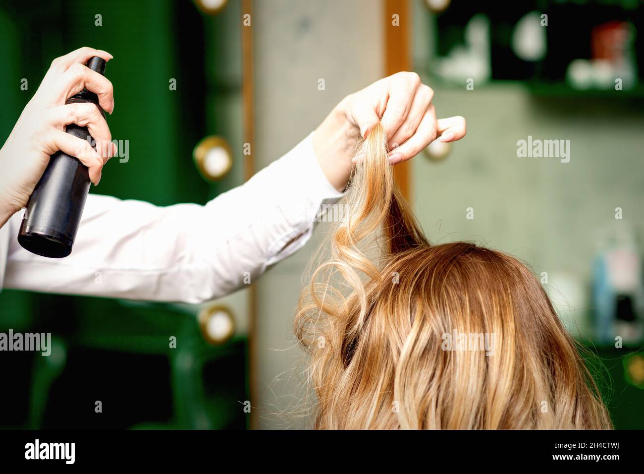 Donna coiffeur fissaggio capelli donna bionda con hairspray in un salone di  bellezza Foto stock - Alamy