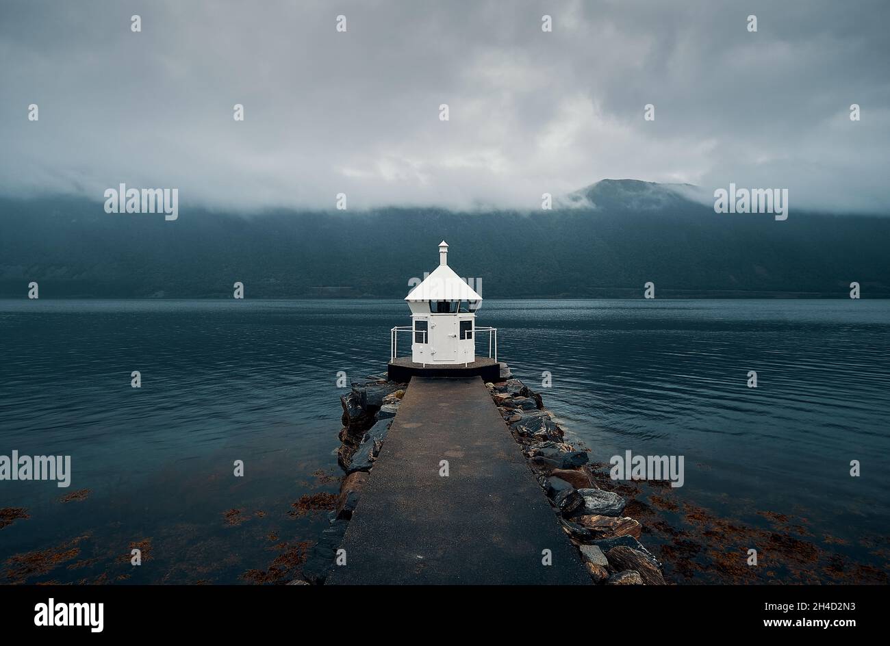 Faro all'interno di un fiordo in una giornata piovosa, Norvegia Foto Stock