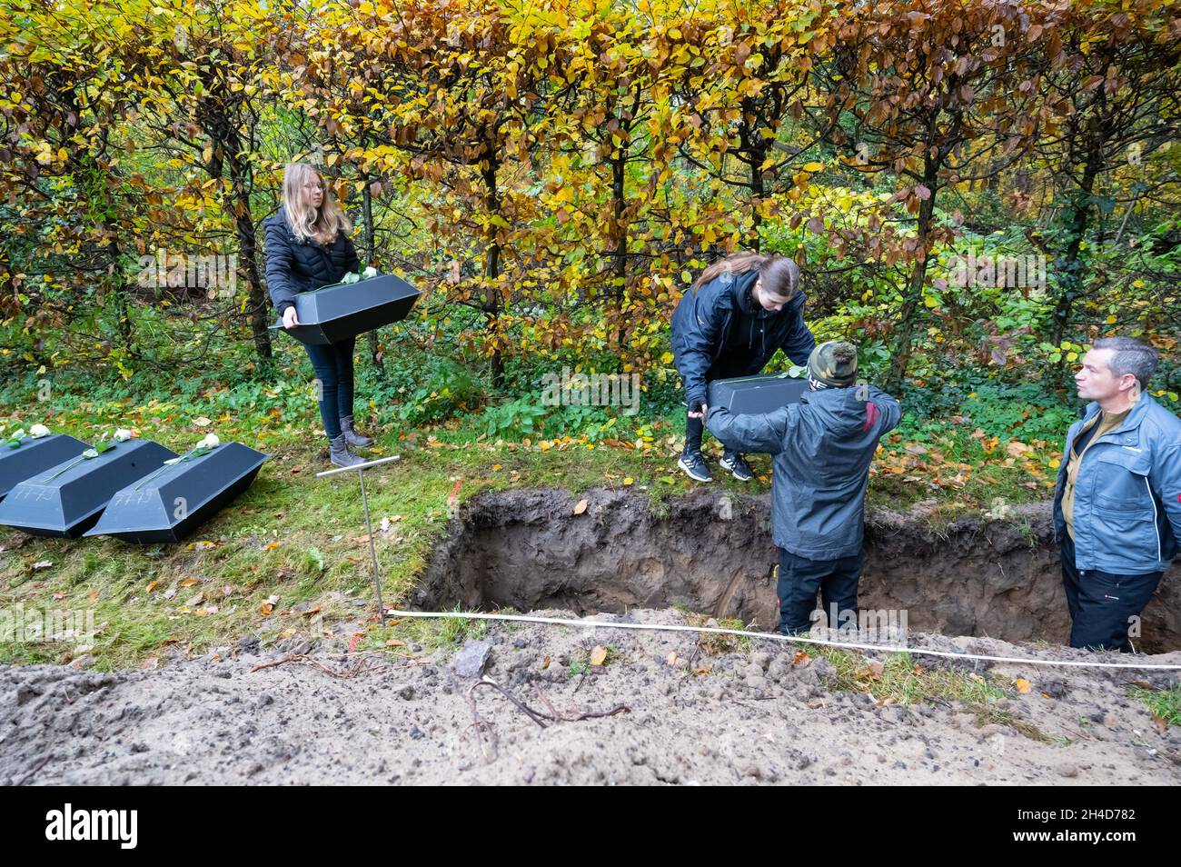 Dresda, Germania. 2 novembre 2021. Gli alunni delle classi nono-grado in una scuola secondaria di Dresda stanno aiutando a seppellire i morti di guerra dalla Commissione delle tombe di guerra tedesche. Durante i lavori di costruzione nel centro di Dresda lo scorso anno, sono stati rinvenuti i resti delle più probabili vittime della guerra civile, che sono state ora poste a riposo nelle casse del cimitero di guerra di Johannis. Credit: Matthias Rietschel/dpa/Alamy Live News Foto Stock