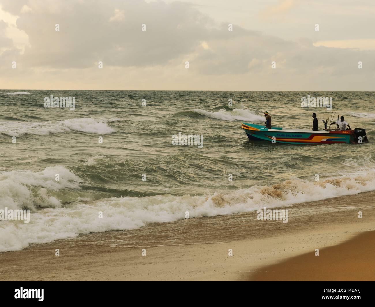 I pescatori sulla loro nave da pesca a Dehiwala Beach, dirigendosi verso il vasto oceano sperando di tornare con una barca piena di pesci. Era piuttosto bello vederli spingere la barca dalla spiaggia al mare. Foto Stock