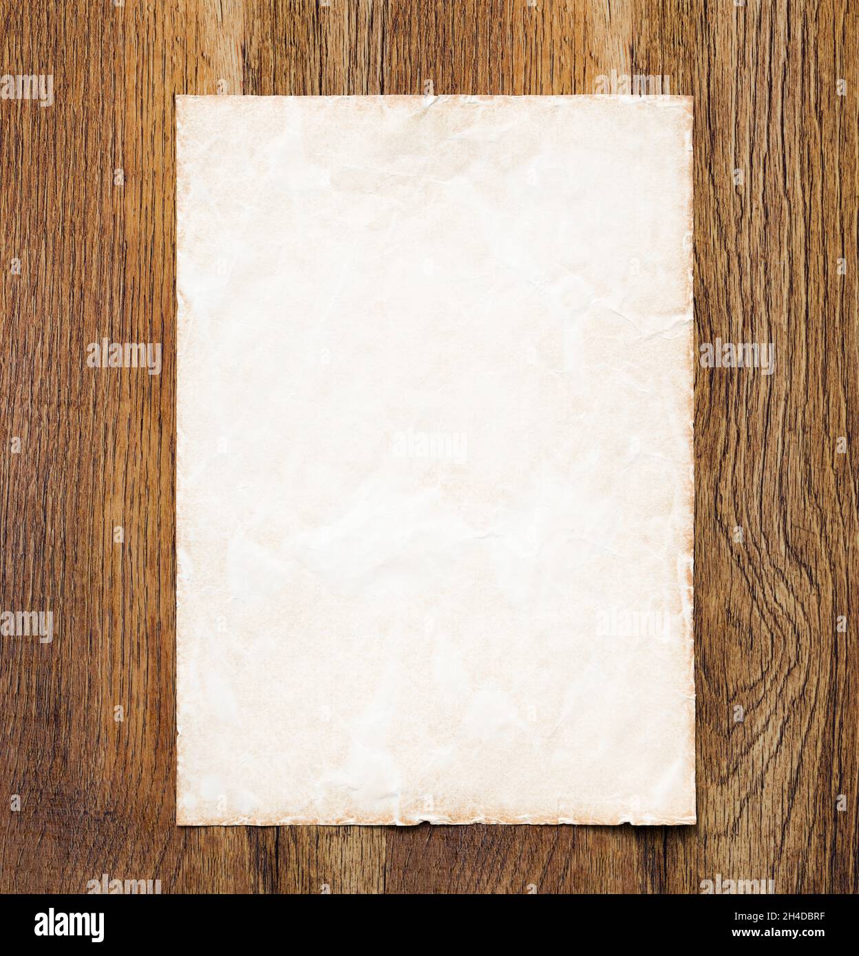 Elemento grafico vintage background. Foglio di vecchia carta pergamena su una scrivania di legno scuro. Ideale per un modello di sito Web o un bordo Foto Stock