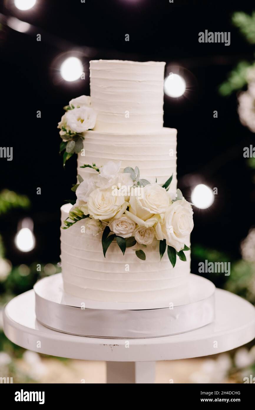 Bella torta bianca deliziosa di nozze la sera Foto Stock