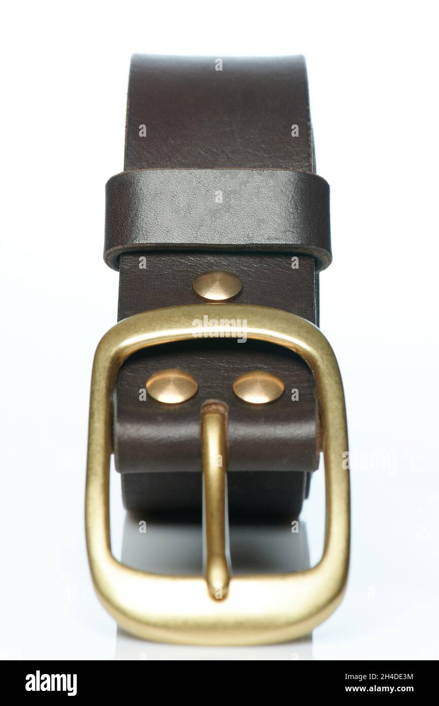 Cintura in pelle arrotolata con fibbia in metallo isolata sullo sfondo dello studio Foto Stock