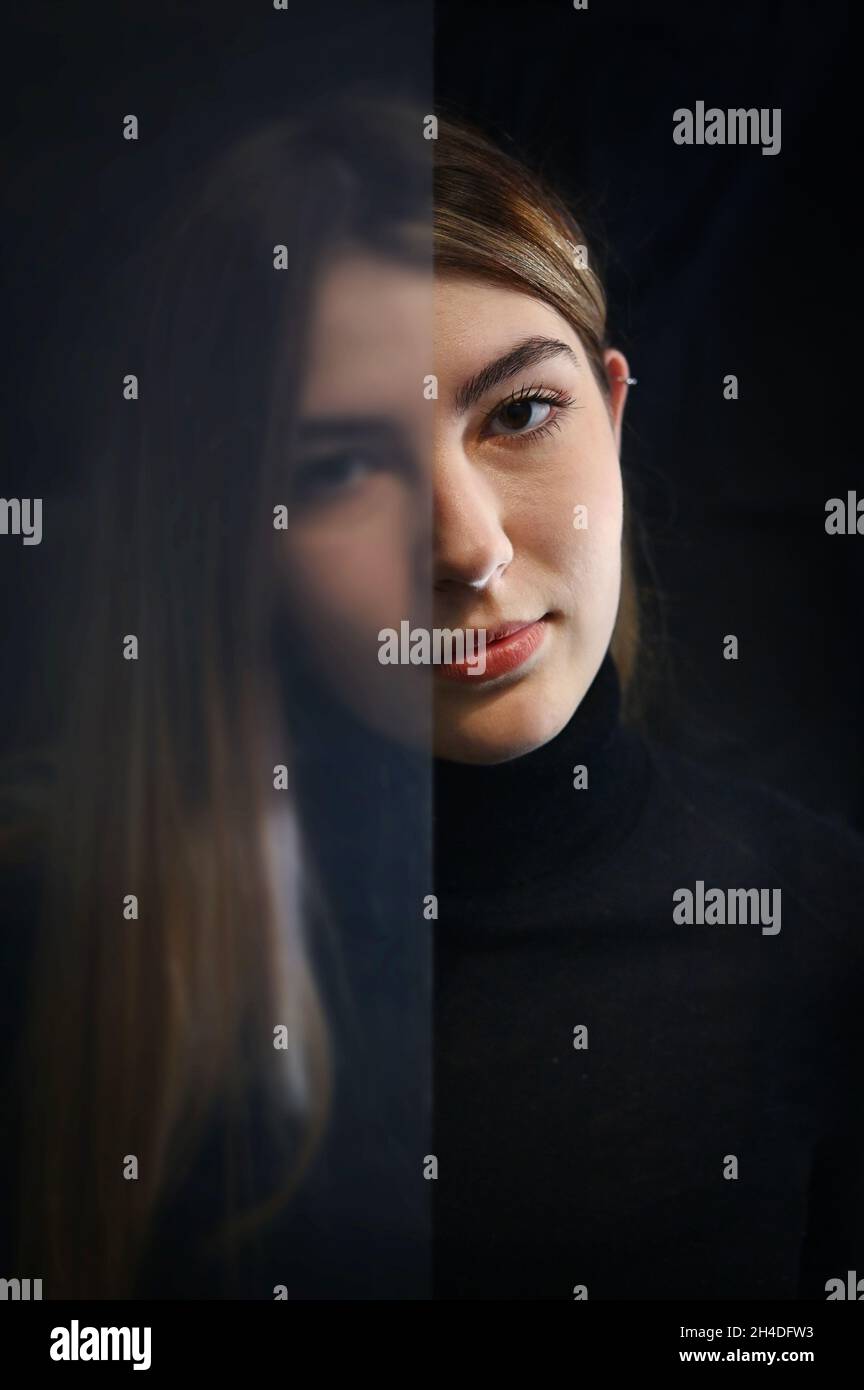 Primo piano Ritratto giovane donna vista attraverso il vetro semi-opaco Foto Stock