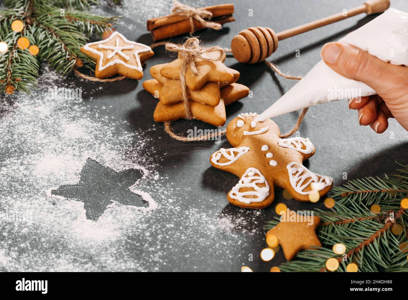 Sfondo di Natale con biscotti fatti in casa di pan di zenzero uomo coperto con glassa sul tavolo nero, spazio copia. Cibo festivo, cartolina, festa Foto Stock