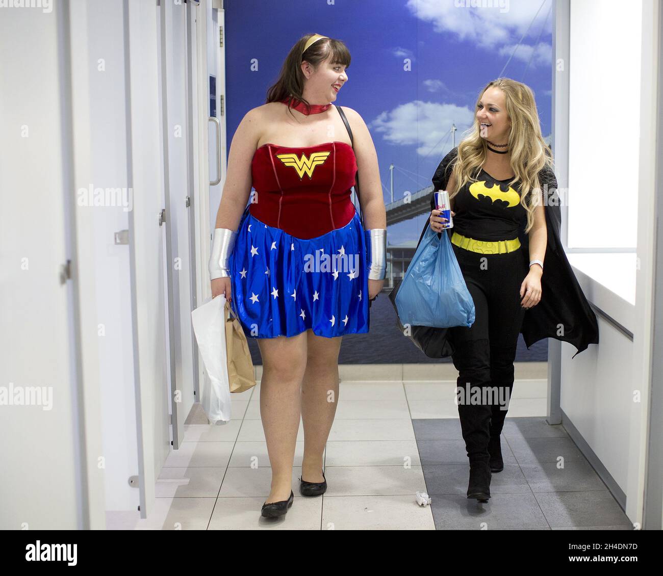 Un paio di cosplayers vestiti come Batwoman e Wonder Woman camminano lungo il gabinetto delle Signore al MCM London Comic con a Londra Excel . Foto Stock