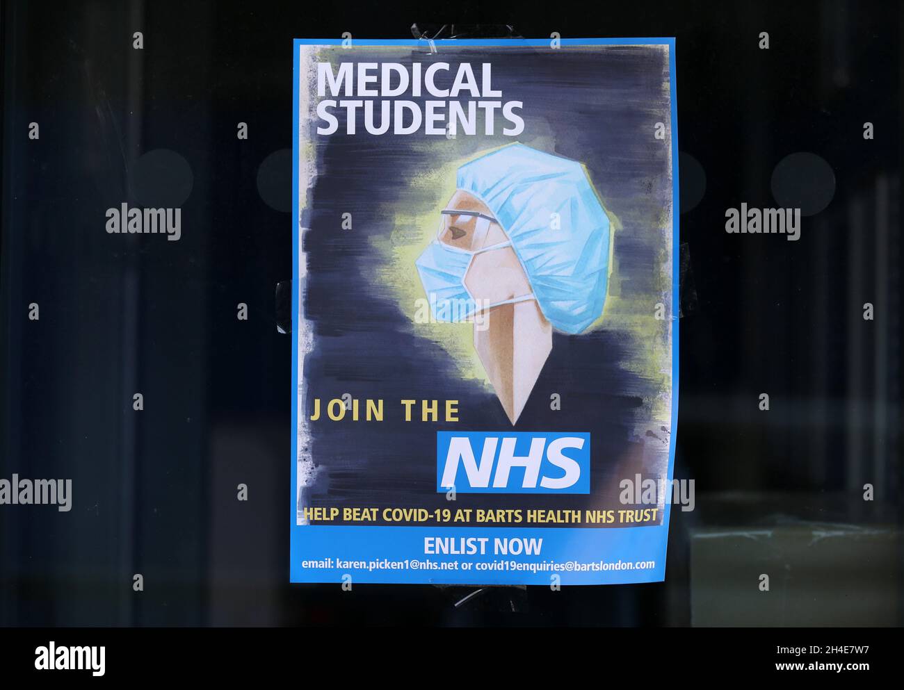 Un poster che illustra un operatore sanitario che indossa PPE (dispositivi di protezione individuale) chiedendo agli studenti di medicina di unirsi al NHS per aiutare a battere il codice 19 presso Barts Health NHS Trust, è visualizzato in una finestra fuori del Royal London Hospital a Whitechapel, a est di Londra, Mentre il Regno Unito continua a bloccarsi per contribuire a frenare la diffusione del coronavirus. Data foto: Venerdì 24 aprile 2020. Foto Stock