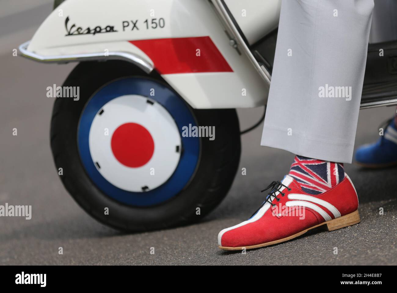 Un uomo indossa dei calzini Union Jack mentre guida la sua vespa al Cenotaph, a Whitehall, Londra, per celebrare il 75° anniversario della VE Day. Data foto: Venerdì 8 maggio 2020. Foto Stock