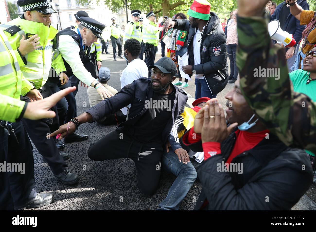 La polizia ha frenato i manifestanti che protestano contro le interferenze francesi negli affari interni del Camerun davanti al presidente francese Emmanuel Macron mentre stava partecipando ad un evento ufficiale con il primo ministro britannico Boris Johnson durante la sua visita nel Regno Unito per celebrare l'80° anniversario del leader francese di resistenza Charles de Gaulleâ trasmissione in tempo di guerra. Data foto: Giovedì 18 giugno 2020. Foto Stock