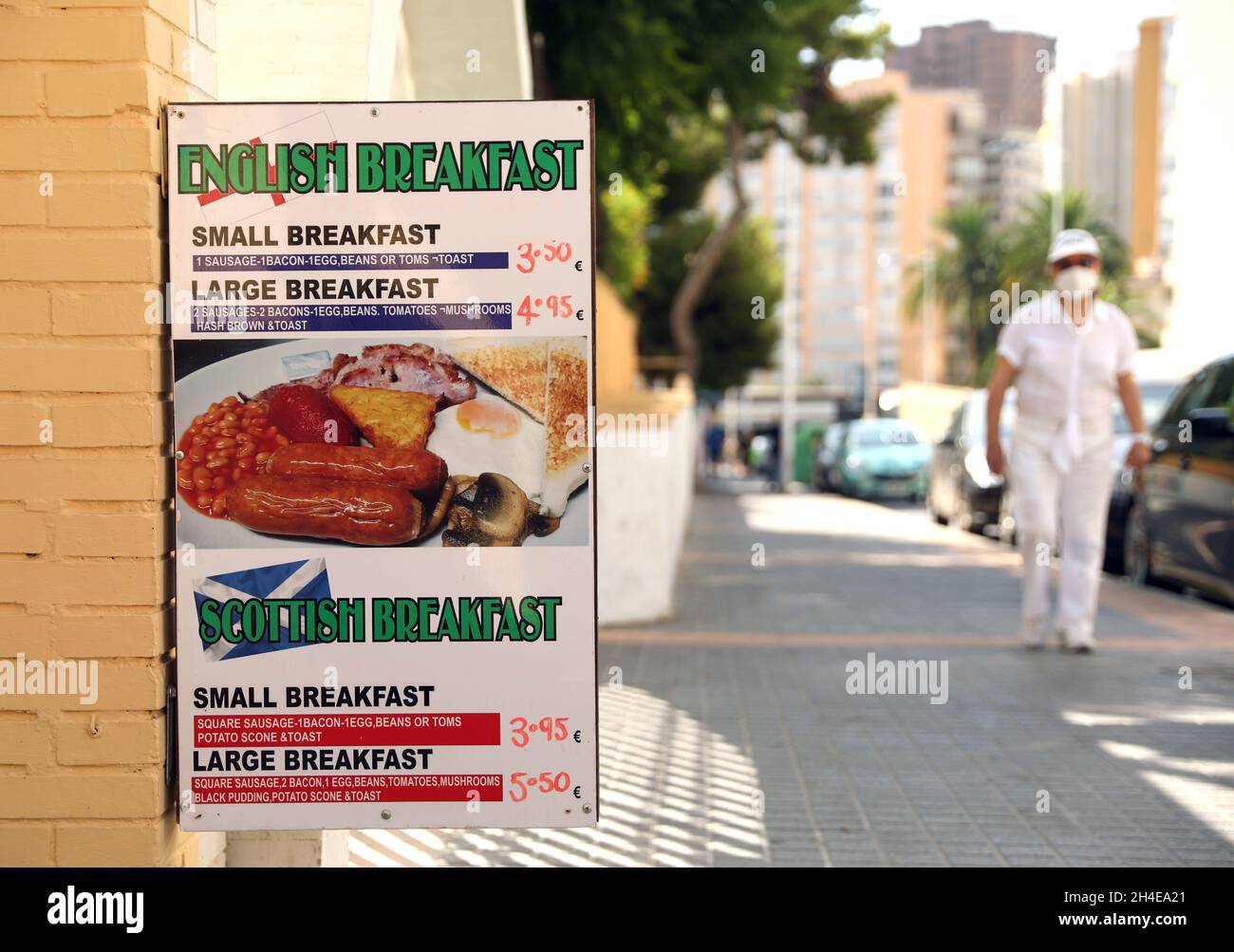 Un viso turistico che copre passeggiate davanti a un tranquillo bar che vende colazione inglese e scozzese a Benidorm, una località balneare sulla costa orientale della Spagna, Come l'industria del turismo in Spagna è stato colpito duramente dall'ultimo requisito di quarantena di 14 giorni da parte del governo britannico per tutti i turisti che viaggiano dalla Spagna a causa dei suoi alti livelli di casi COVID-19. Data foto: Venerdì 31 luglio 2020. Foto Stock