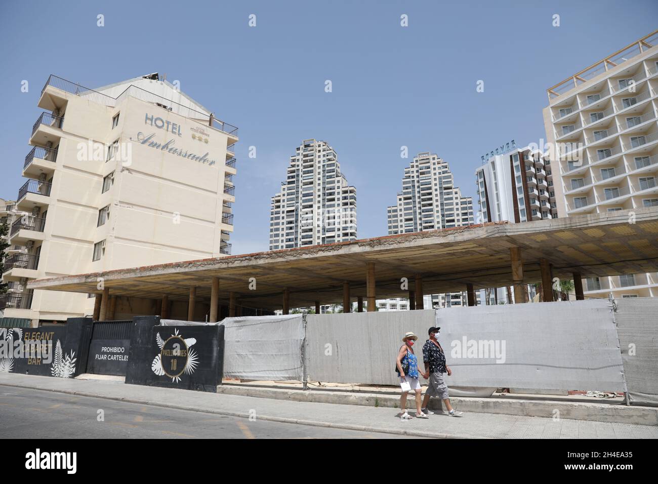 I turisti passano davanti a una strada vuota nel distretto inglese di Levante a Benidorm, una località balneare sulla costa orientale della Spagna, che rimane quasi vuota dopo la quarantena del governo britannico a tutti i turisti che viaggiano dalla Spagna a causa dei suoi alti livelli di casi COVID-19. Data foto: Giovedì 30 luglio 2020. Foto Stock