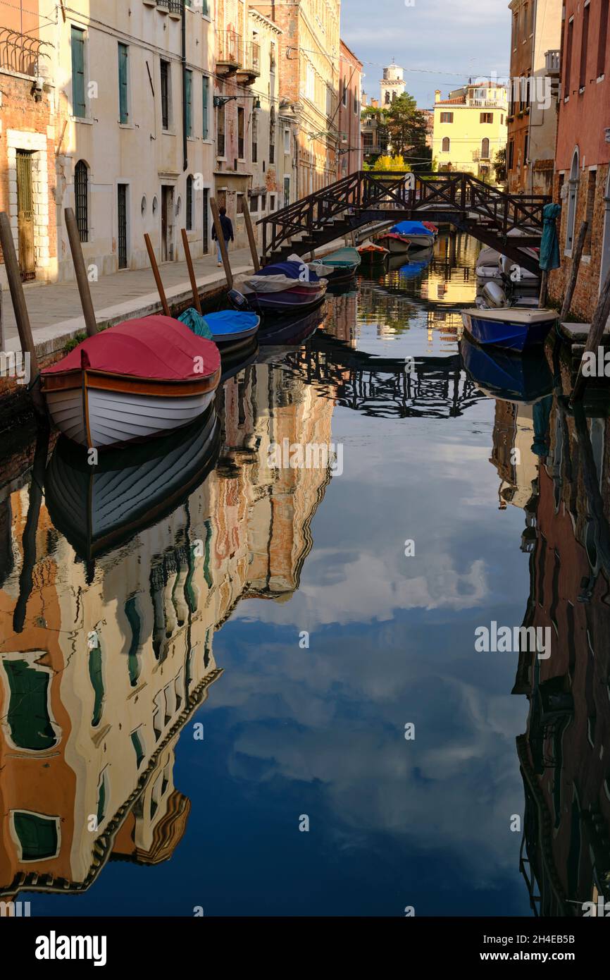 Piccole barche ormeggiate lungo il canale di Venezia Foto Stock