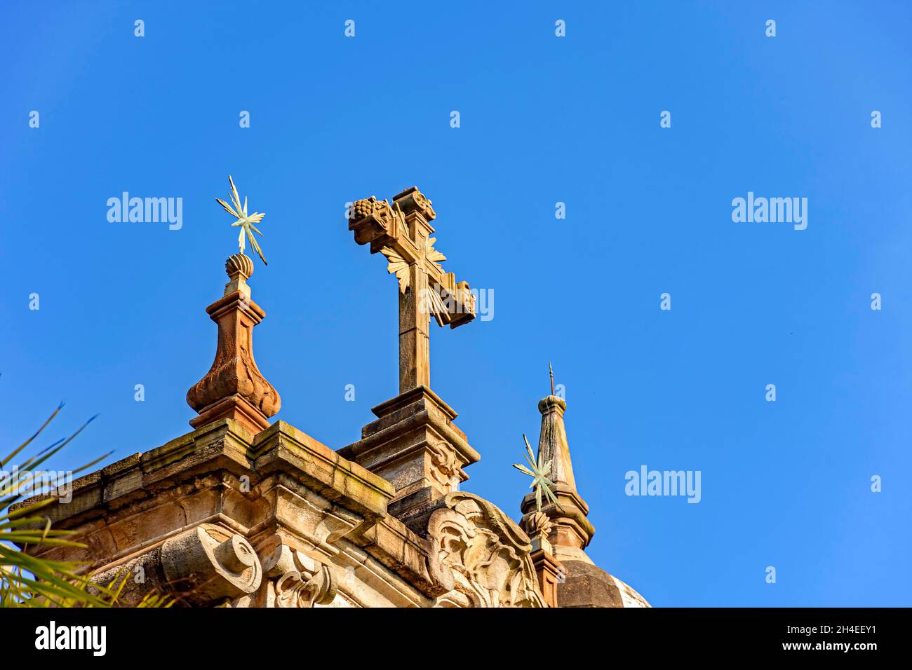 Crocifisso e ornamenti sulla facciata di una vecchia e storica chiesa barocca nella città di Ouro Preto a Minas Gerais Foto Stock