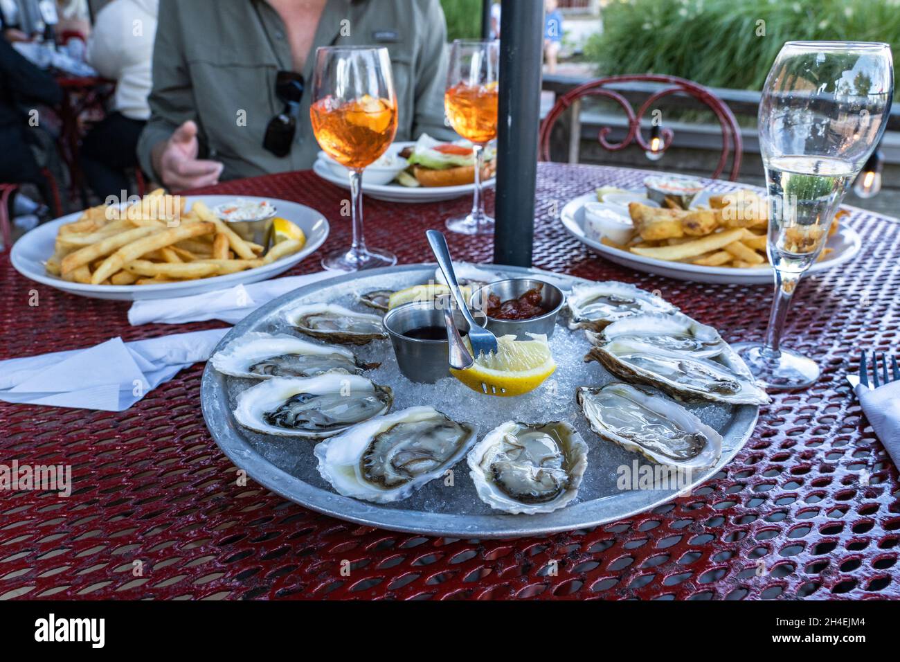 Ostriche, pesce e patatine e cocktail presso la caffetteria all'aperto Foto Stock