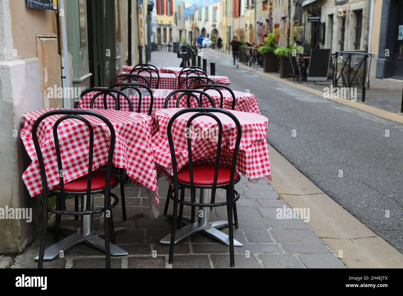 Vista sulla strada della parte più recente di Carcassonne, Francia. Tavoli da caffe' sul marciapiede con tovaglia rosso-bianco a motivi di gingham. Foto Stock
