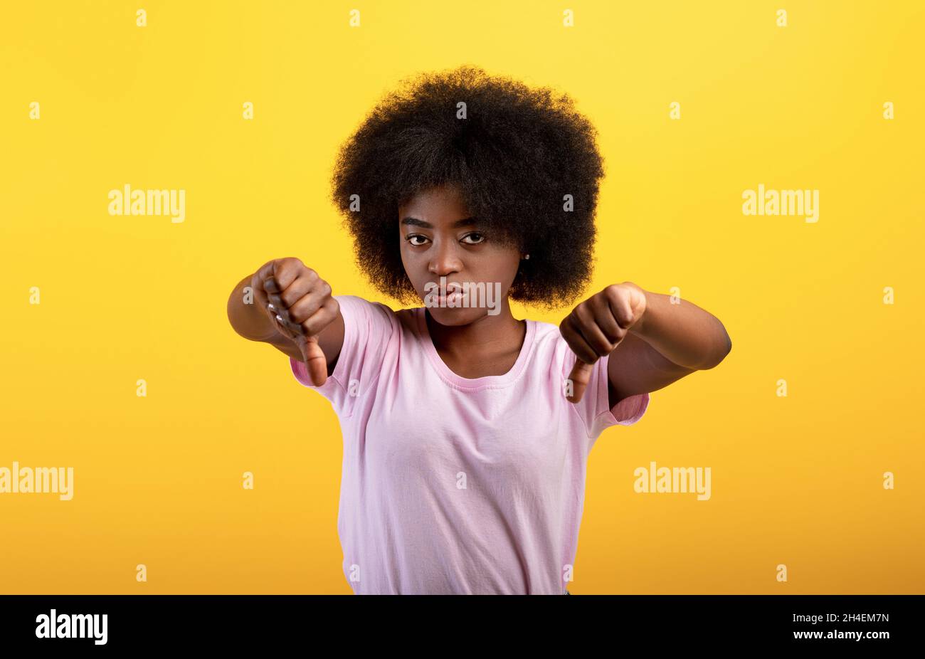 Non mi piace. Signora nera infelice che mostra il pollice verso il basso gesto, dispiaceva la giovane donna che esprimeva disapprovazione Foto Stock