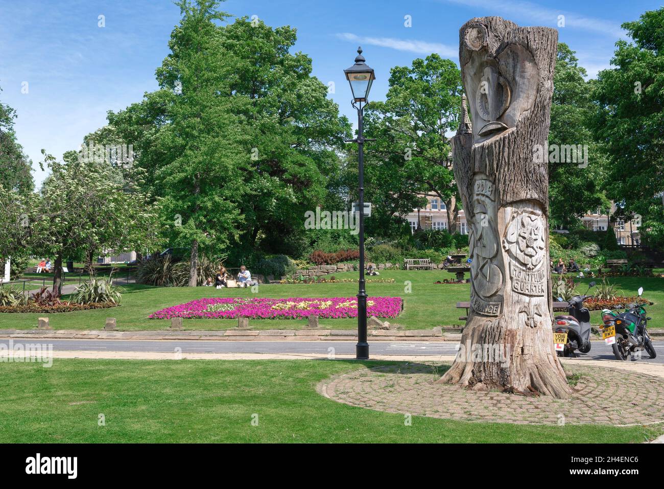 Harrogate, vista in estate dei giardini della Parata di Montpellier e una scultura dell'albero che segna il bordo meridionale del quartiere di Montpellier, Harrogate, Inghilterra Foto Stock