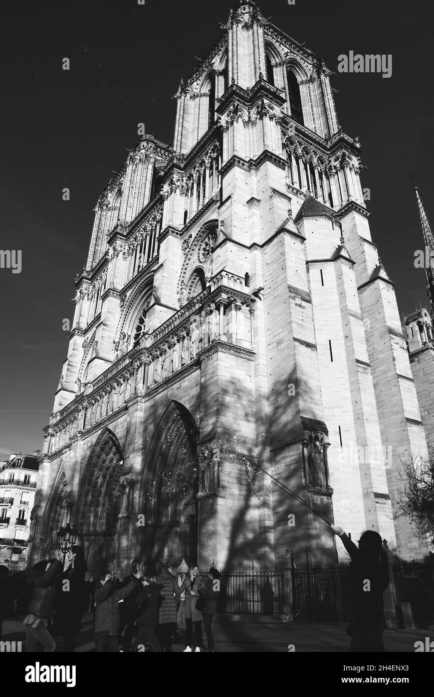 PARIGI, FRANCIA - 14 FEBBRAIO 2019: I bambini giocano con enormi e colorate bolle di sapone vicino alla Cattedrale di Notre Dame. Soapbollicine creare alone in cielo per Notre Foto Stock