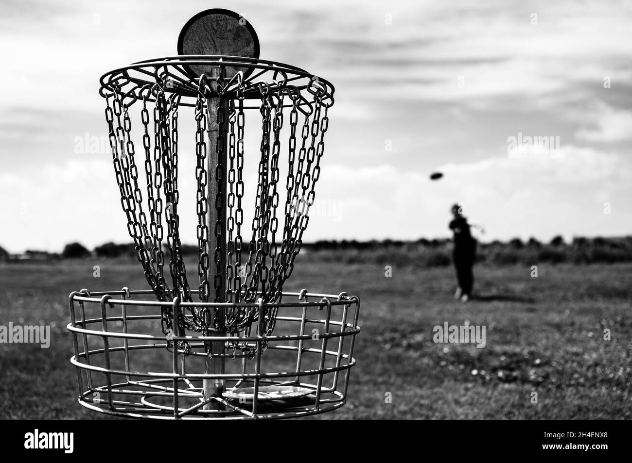 Concentratevi su un buco da golf mentre il disco è in aria dopo essere stati lanciati da un giocatore defocalizzato Foto Stock