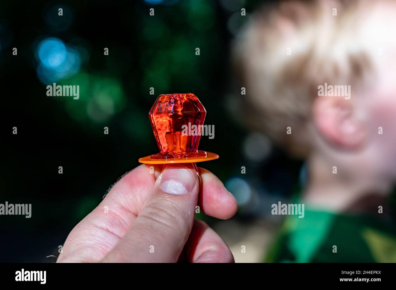 Anello a forma di diamante sucker caramella che è tenuto in su con un  bambino defocused nello sfondo Foto stock - Alamy