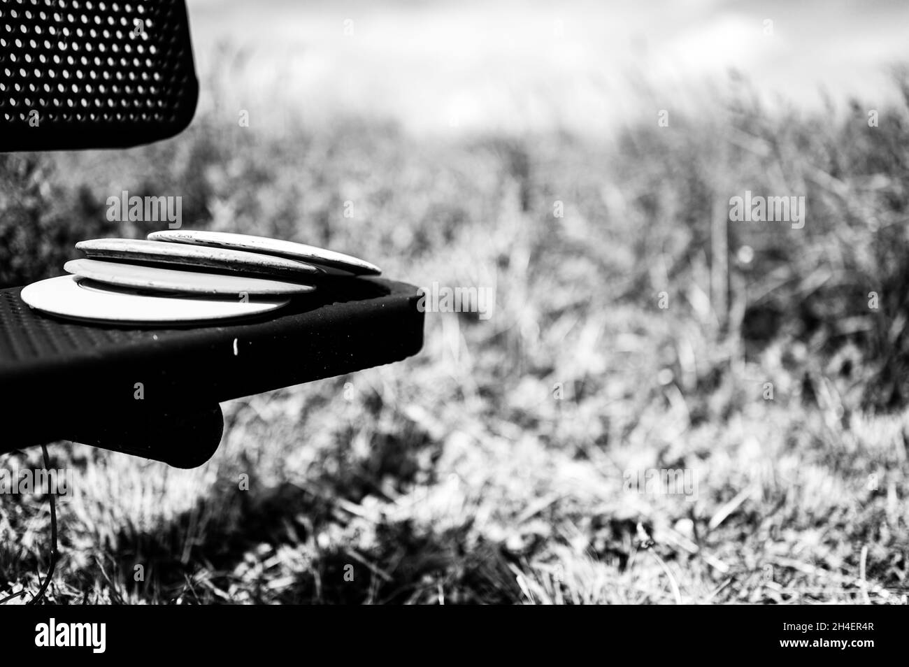 Pila di dischi appoggiati su una panca nel parco del campo da golf Foto Stock