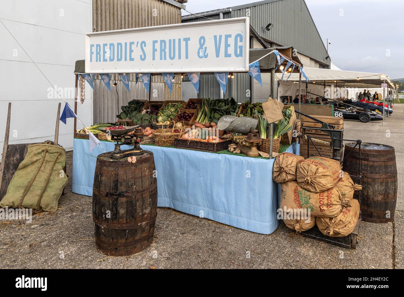 La bancarella di frutta e bevande di Freddie. Uno stand di mercato di mock-up con frutta e verdura reali al 78 ° Goodwood Members Meeting, Sussex, Regno Unito. Foto Stock