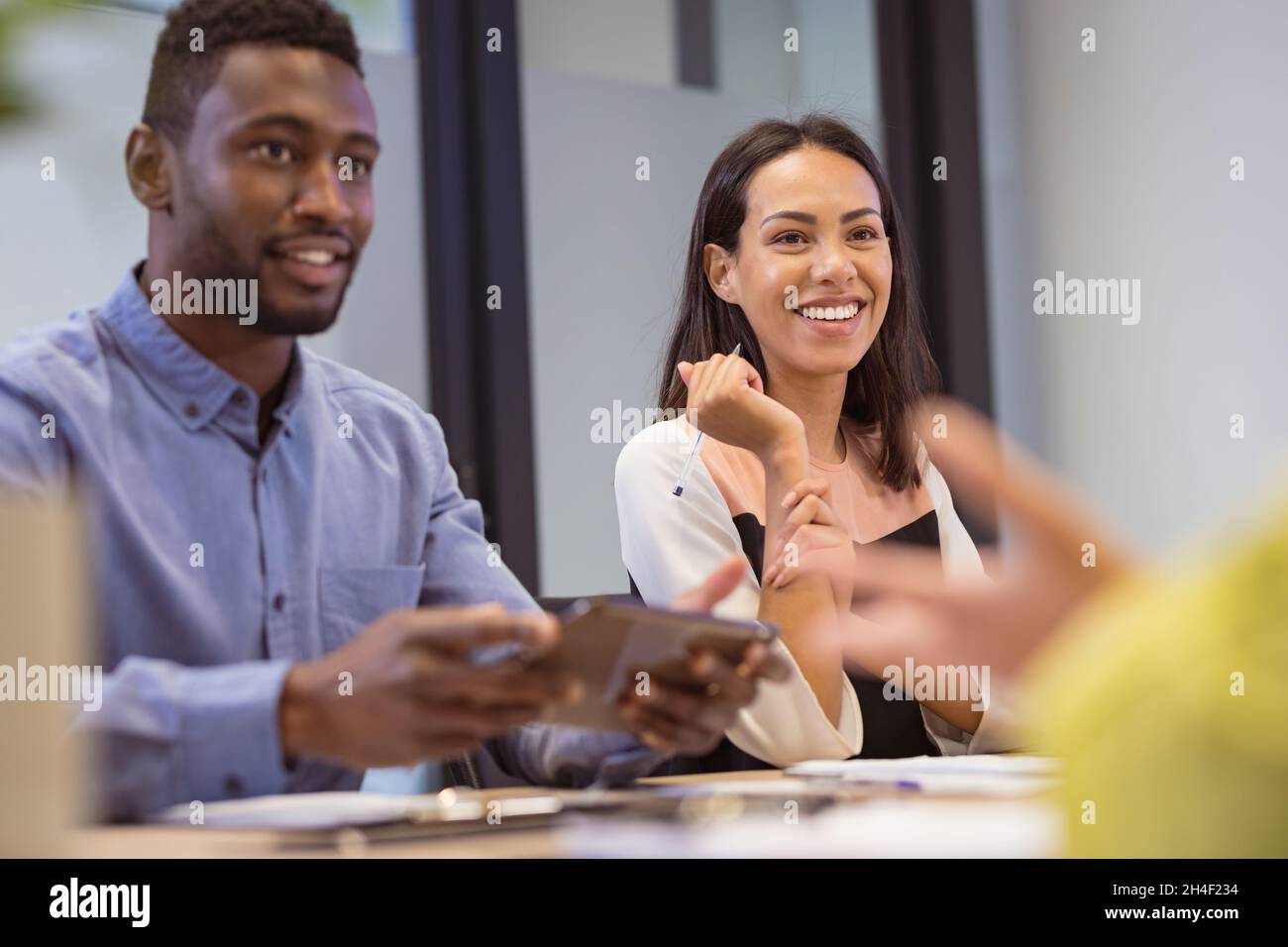 Gruppo felice di persone d'affari diverse che discutono di lavoro in un ufficio moderno Foto Stock