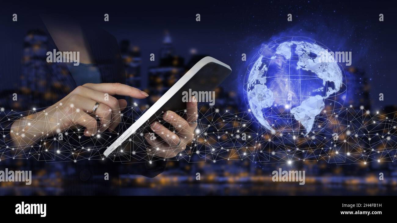 Concetto di connessione globale. Tablet bianco con tocco a mano e segno ologramma digitale su sfondo sfocato scuro della città. Rete globale contro un backgroun oscuro Foto Stock