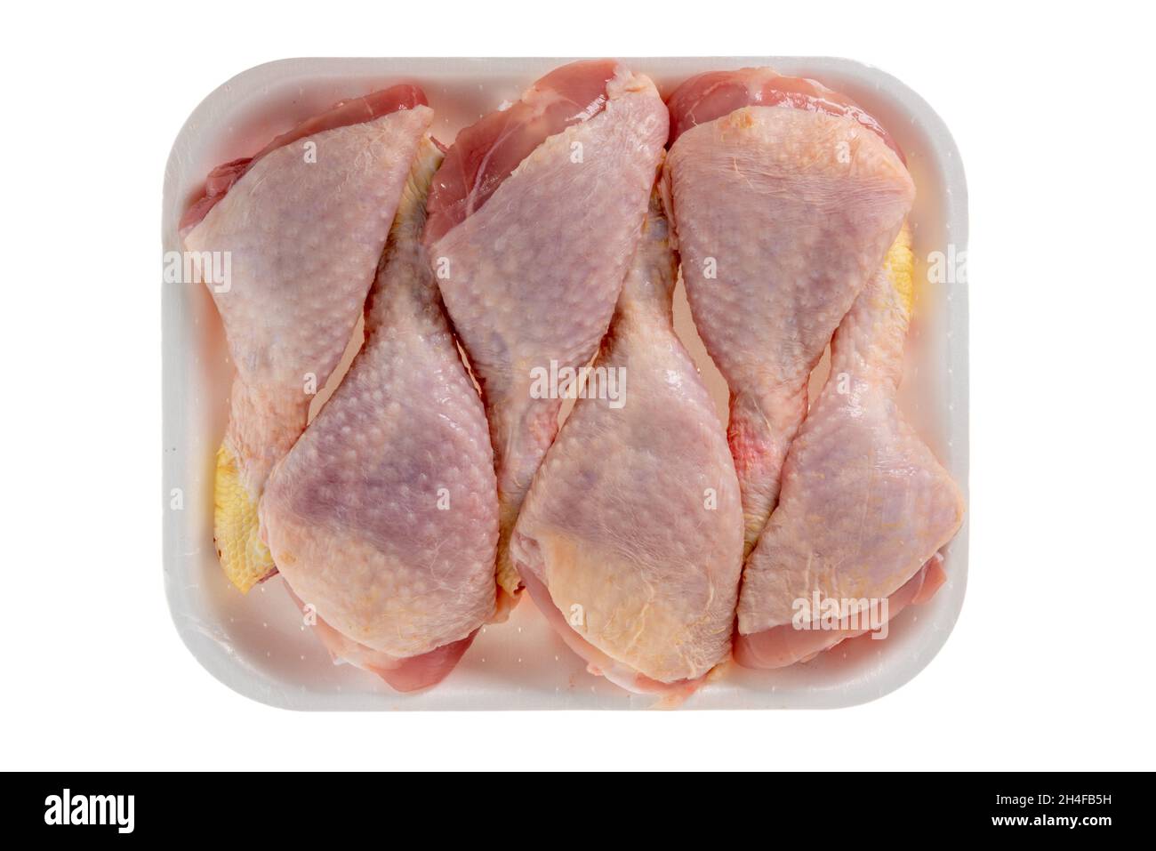 sei cosce di pollo in vassoio di plastica isolato su sfondo bianco, percorso di taglio, vista dall'alto Foto Stock