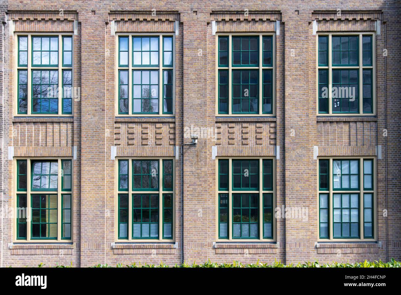 Amsterdam, Paesi Bassi-Maggio 2021: Primo piano di finestre e facciata in mattoni 1920 edificio di ex Koninklijke Hollandse Lloyd società di navigazione Foto Stock
