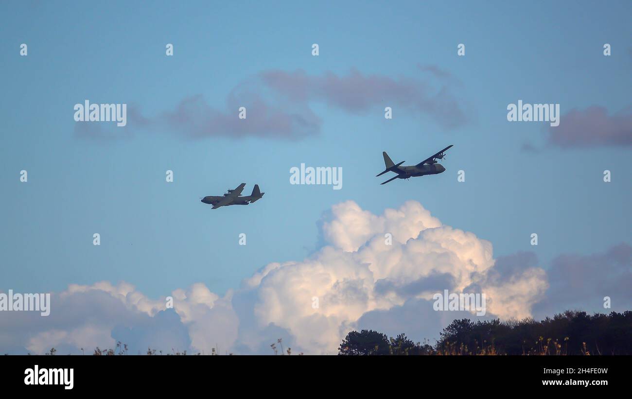 Due traversate che si sovrappongono al British RAF Lockheed Martin C-130J Hercules aereo su un esercizio militare carico paracadute drop correre sopra Salisbury Plain, Regno Unito Foto Stock