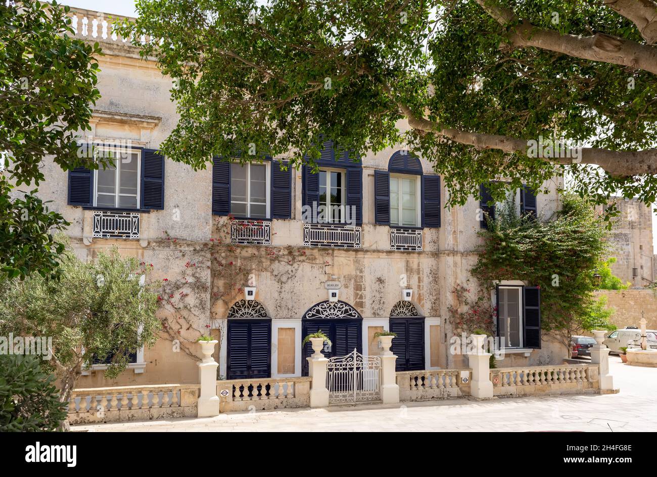 Casa pittoresca a Mdina, Malta, con porte blu navy e persiane, con modanature bianche innevate e cancello recinzione. Foto Stock Casa pittoresca a Mdina, Malta, con porte blu navy e persiane, con modanature bianche innevate e cancello recinzione. Foto Stock