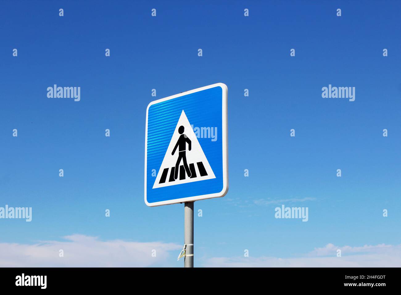 Blau weiß schwarzes Verkehrsschild / Hinweisschild / Gefahrenzeichen 'Fußgängerüberweg', Aufstellung rechts, un einer Straße a Espinho, Portogallo. Foto Stock
