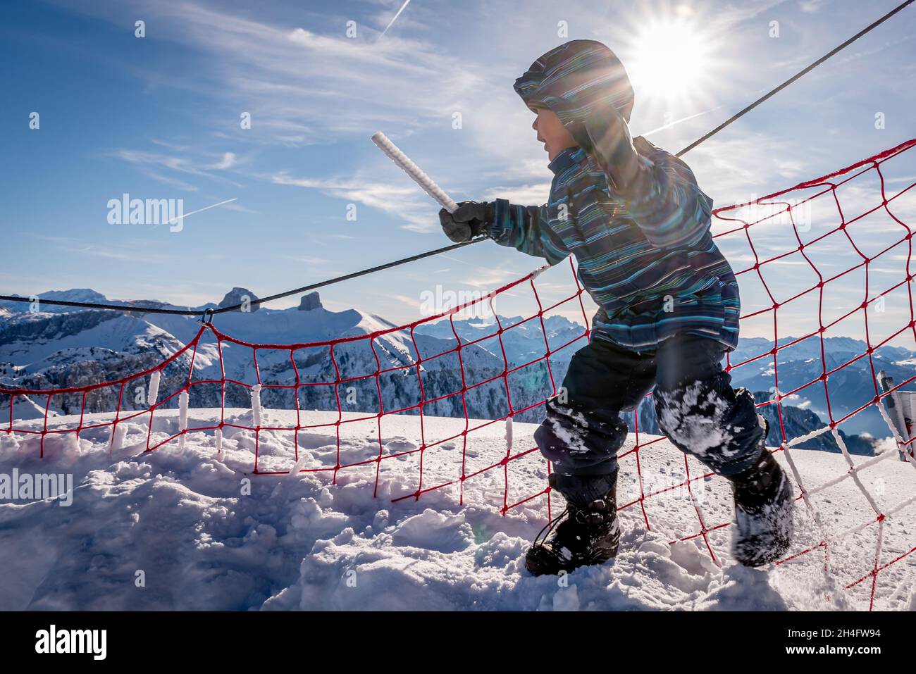 Bambini che giocano nella neve. Un ragazzo asiatico in abbigliamento da sci e guanti da gioco in inverno. Buona infanzia. Foto Stock