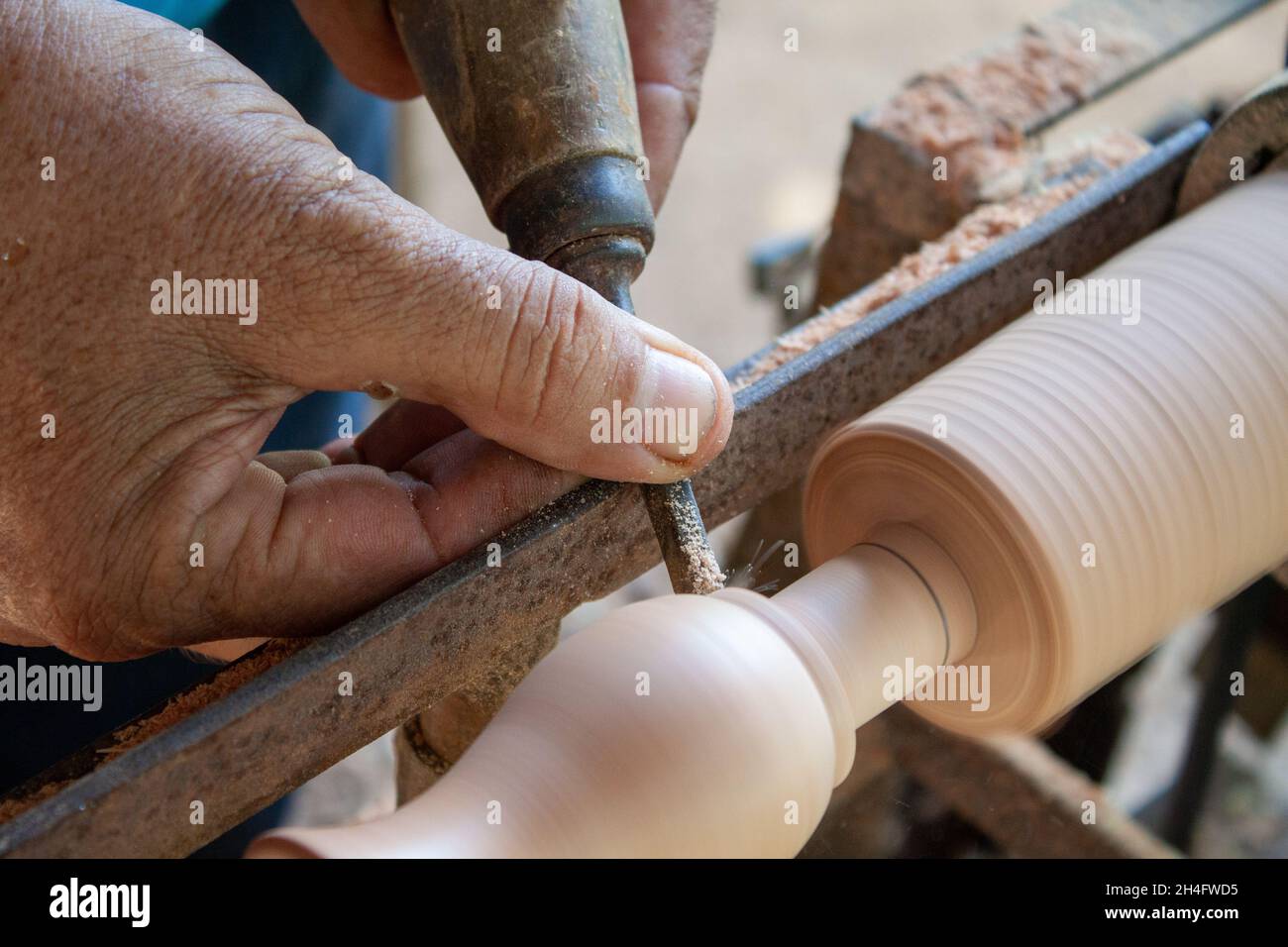 Mani anziane che girano legno Foto Stock