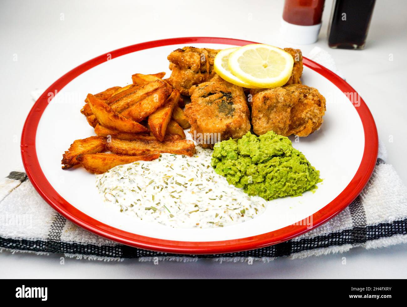 Pesce vegano e patatine fritte con salsa vegana, tofu e patatine fritte con limone. Foto Stock