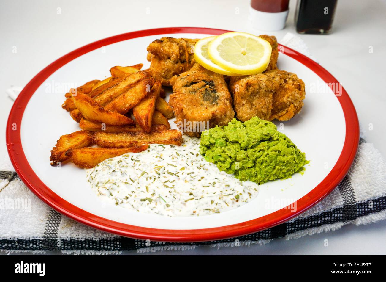 Pesce vegano e patatine fritte con salsa vegana, tofu e patatine fritte con limone. Foto Stock