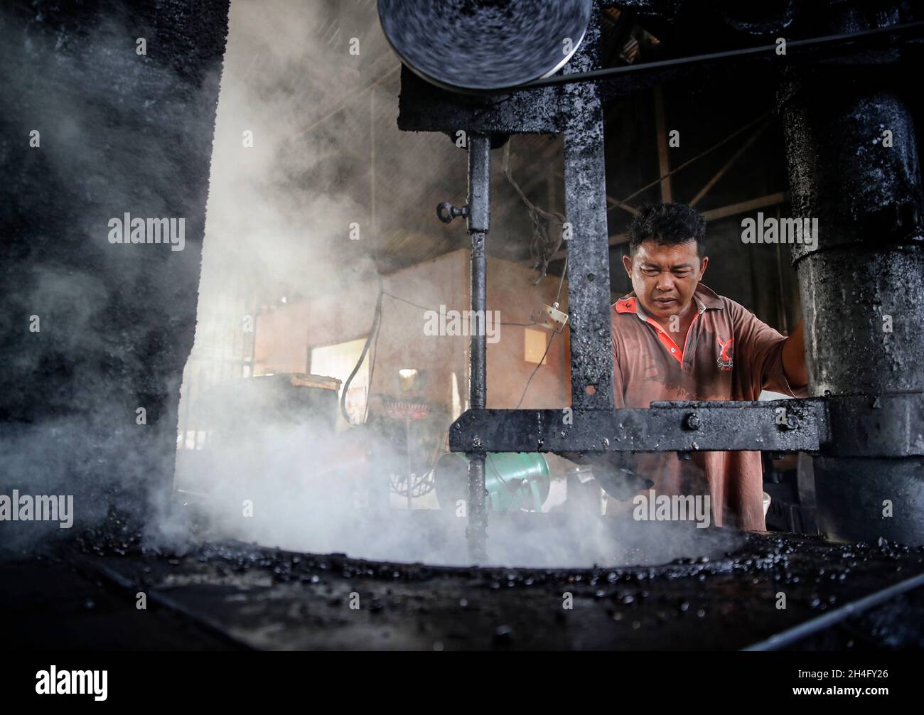 Kuala Lumpur, Malesia. 01 Novembre 2021. Un operaio ha visto cucinare i chicchi di caffè torrefatti con zucchero e burro presso la fabbrica di caffè Chuan Hoe a Klang, nella periferia di Kuala Lumpur. La versione malese di Black Coffee o Kopi-o, prodotta con il metodo della tostatura a carbone, è uno dei preferiti della gente del posto in Malesia. Credit: SOPA Images Limited/Alamy Live News Foto Stock