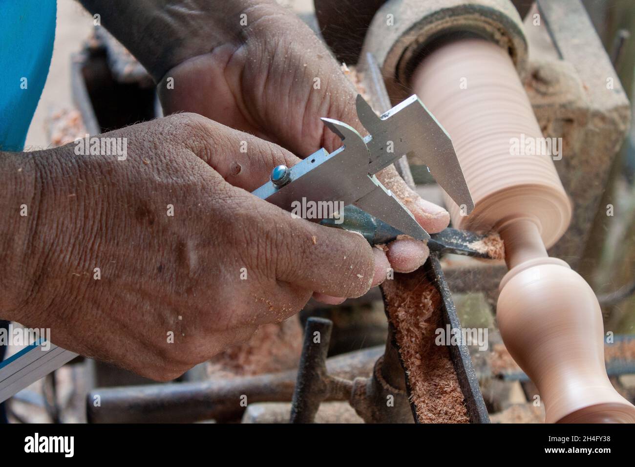 Mani anziane che girano legno Foto Stock