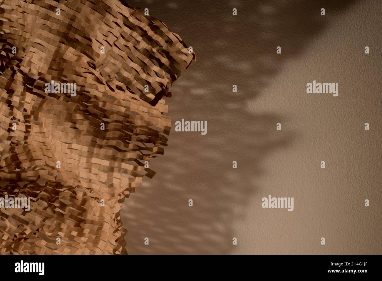 Carta riciclata sostenibile e ombra su un muro. Sfondo concetto di stile di vita sostenibile, spazio di copia per il testo Foto Stock