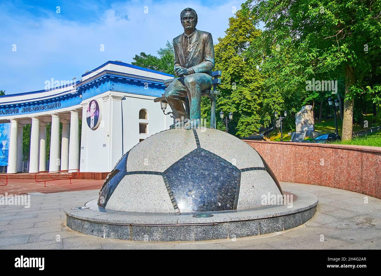 KIEV, UCRAINA - 25 GIUGNO 2021: Monumento al famoso giocatore di calcio ucraino e manager Valeriy Lobanovskyi, seduto sul banco in cima alla palla al Foto Stock