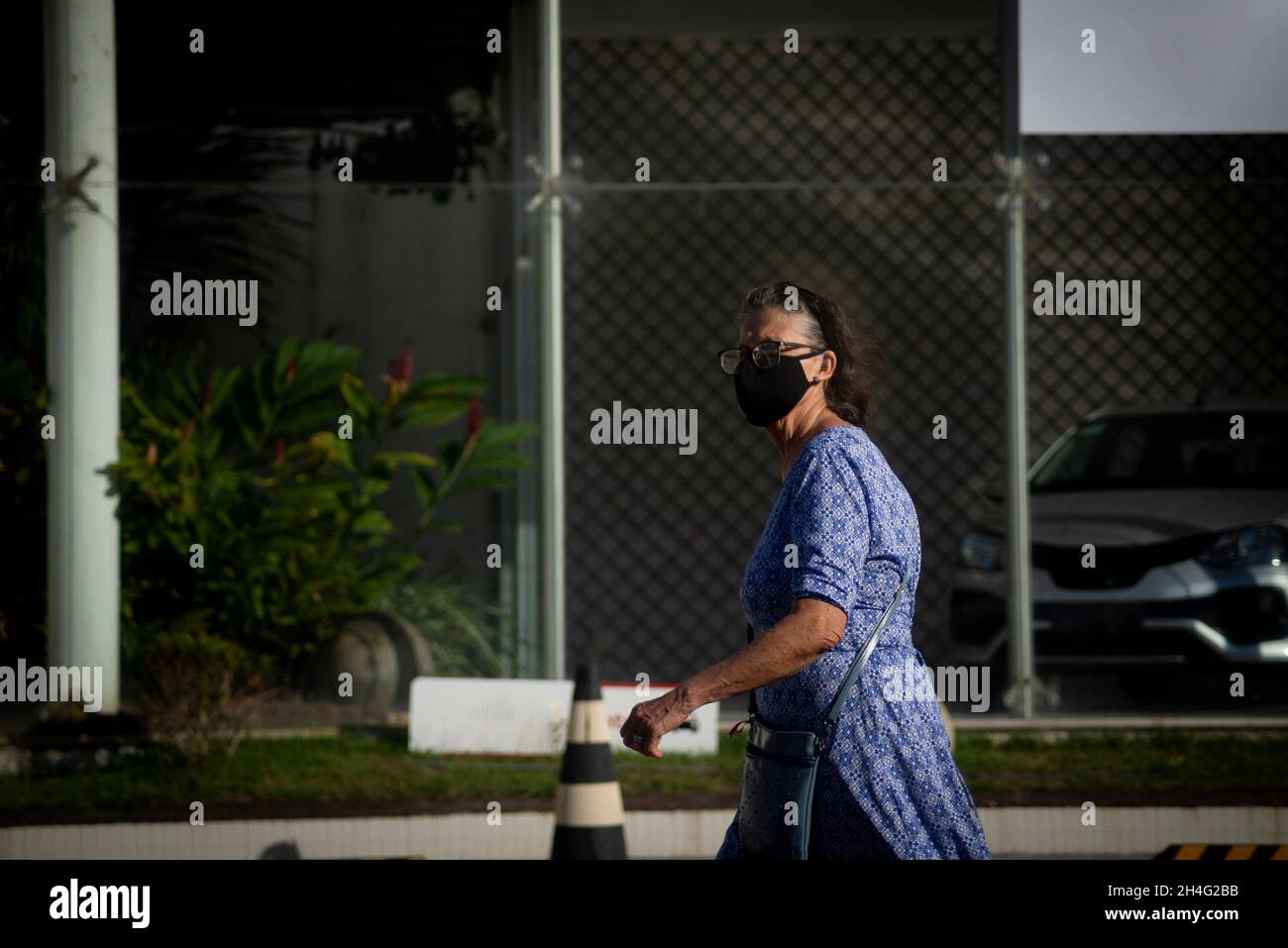 Salvador, Bahia, Brasile - 21 maggio: 2021: Donna che indossa la maschera e cammina per le strade di Salvador, Bahia, Brasile. Foto Stock