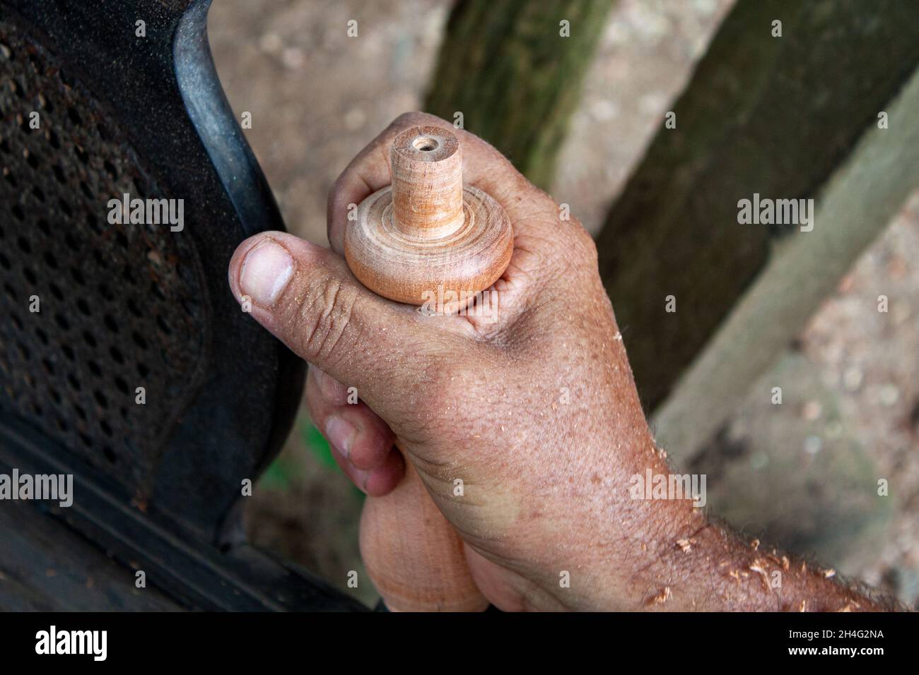 Mani anziane che girano legno Foto Stock