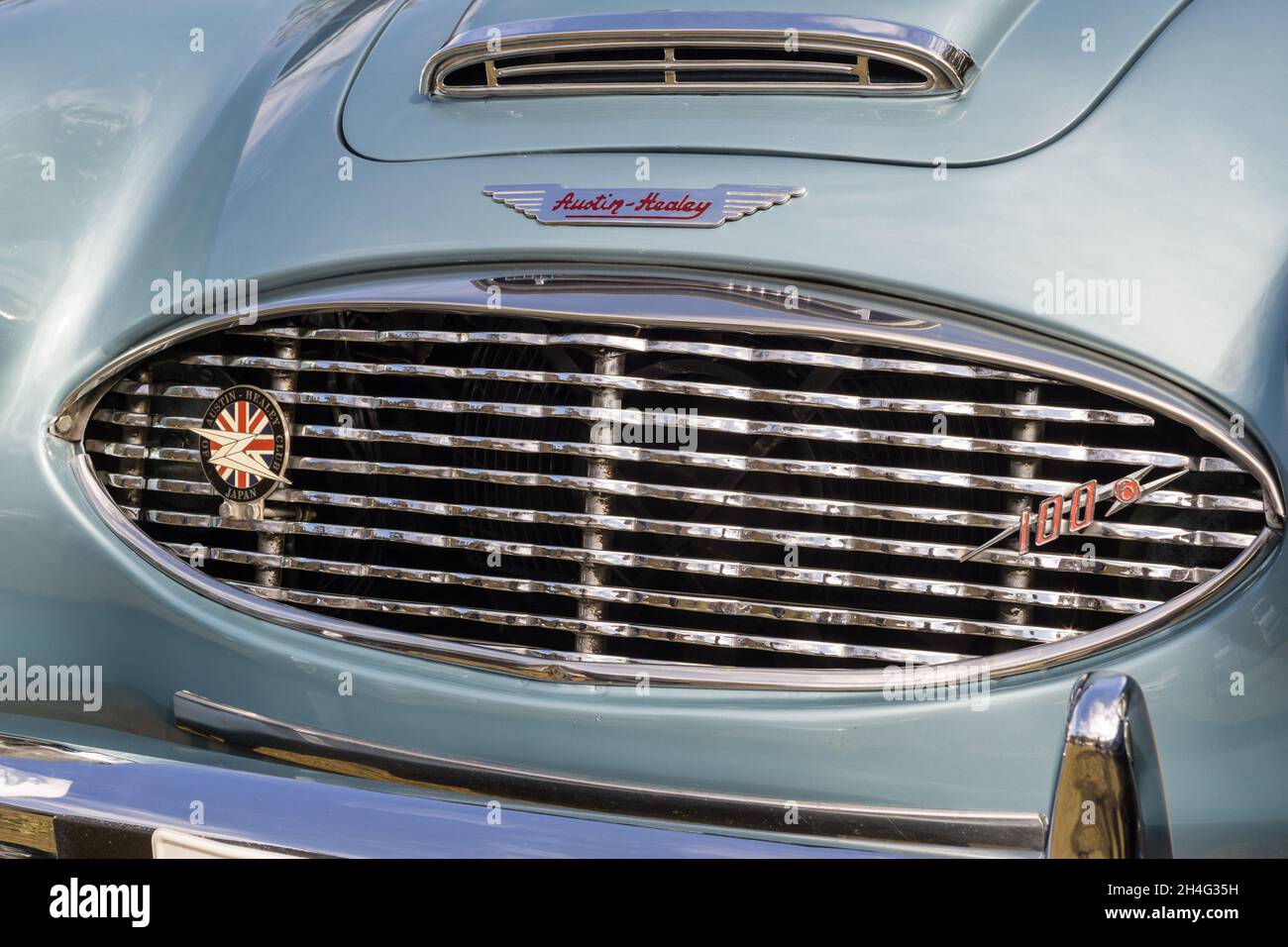 Primo piano dettaglio della griglia frontale cromata su una vettura sportiva Austin-Healey 100-6 British 1950 di colore blu argento con tetto aperto Foto Stock