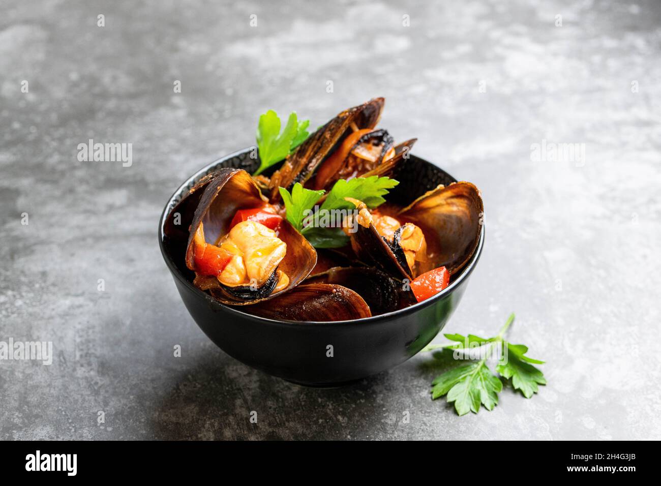 Cozze al vapore in salsa di pomodoro piccante Foto Stock