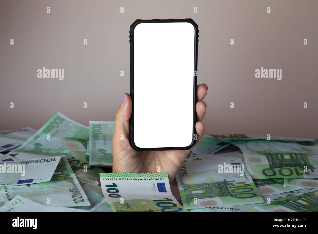 Concetto di utilizzo del telefono, di utilizzo del telefono. Mano con un telefono striscia da un mucchio di soldi Foto Stock