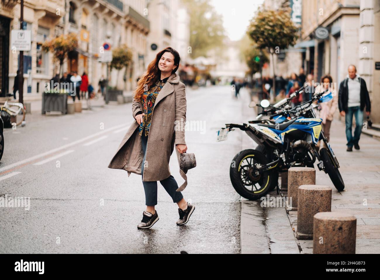 Una bella ragazza romantica in un cappotto con i capelli giù corre  attraverso la città vecchia di Avignone. Francia. Ragazza in un cappotto in  Francia Foto stock - Alamy