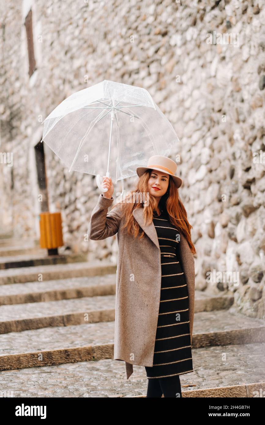 Bella ragazza romantica in un cappotto e cappello con un ombrello  trasparente in Annecy. Francia. La ragazza nel cappello in Francia Foto  stock - Alamy