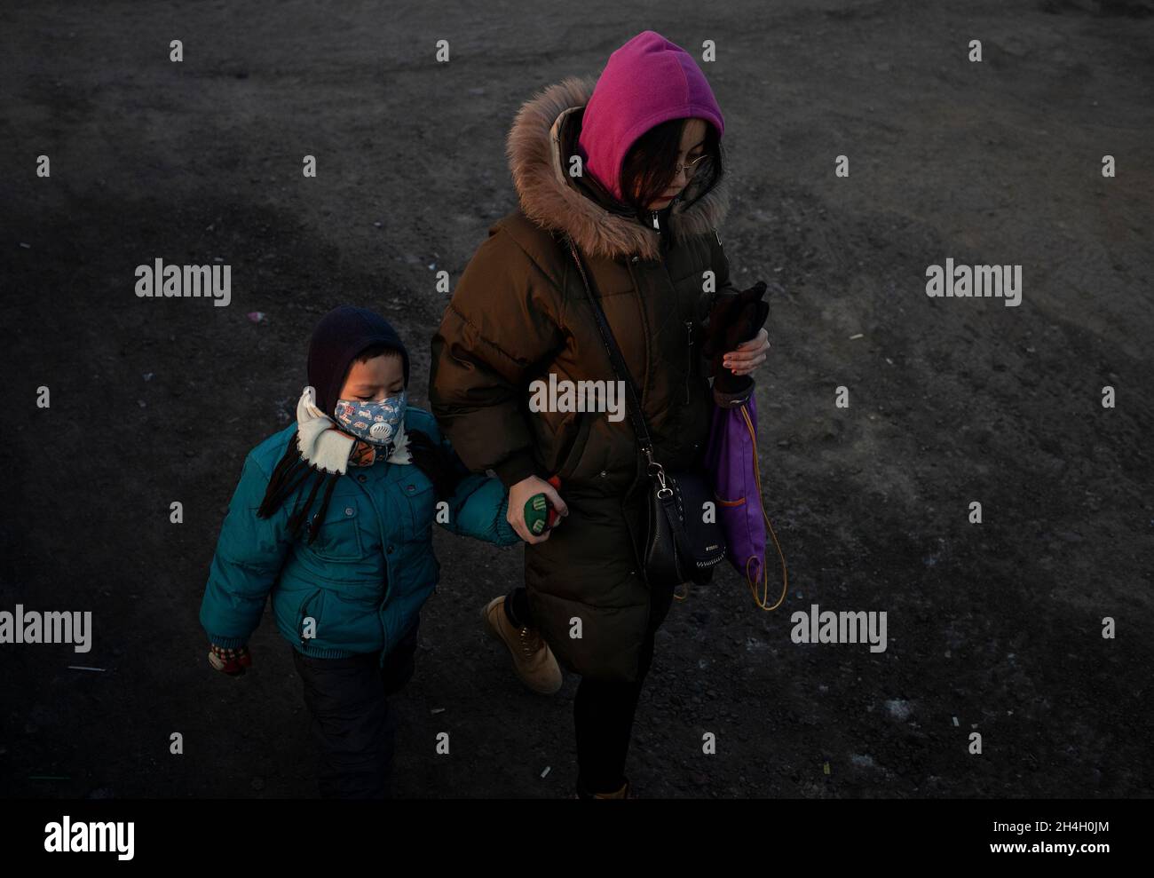 Una madre porta suo figlio in un asilo in uno dei distretti della città, Ulaanbaatar, 21 gennaio 2019. I distretti della città sono em Foto Stock