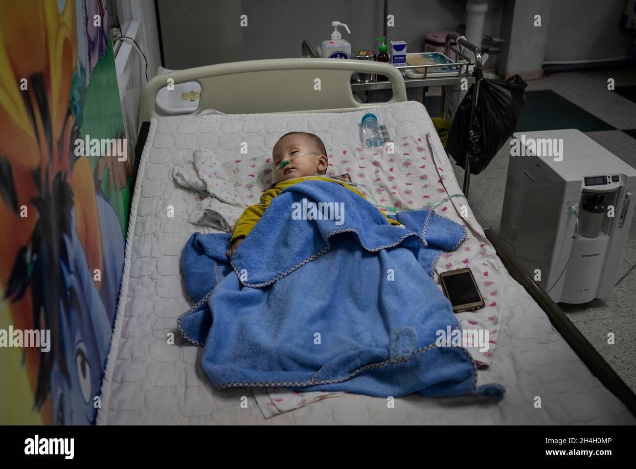 Un bambino che soffre di complicazioni respiratorie si trova in una unità di emergenza pediatrica in uno degli ospedali della città nella capitale Ulaanbaatar, gennaio Foto Stock